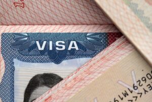 Ilustrasi paspor dan stempel imigrasi Indonesia untuk penjelasan sanksi overstay visa bagi warga negara asing.