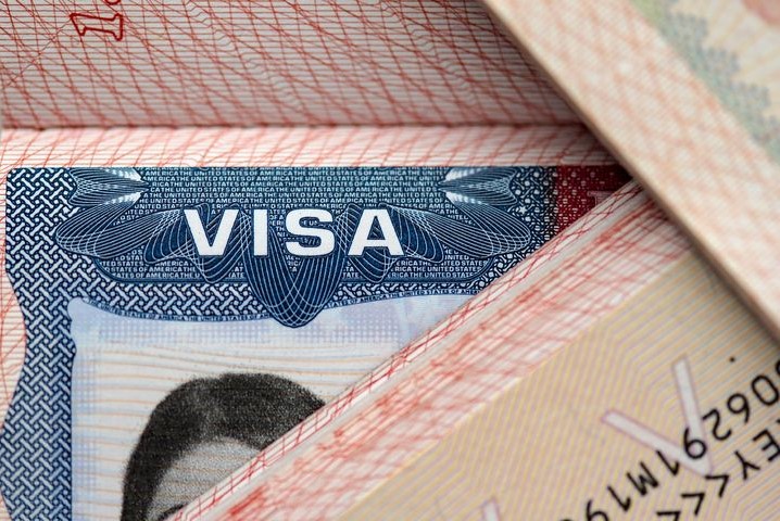 Ilustrasi paspor dan stempel imigrasi Indonesia untuk penjelasan sanksi overstay visa bagi warga negara asing.